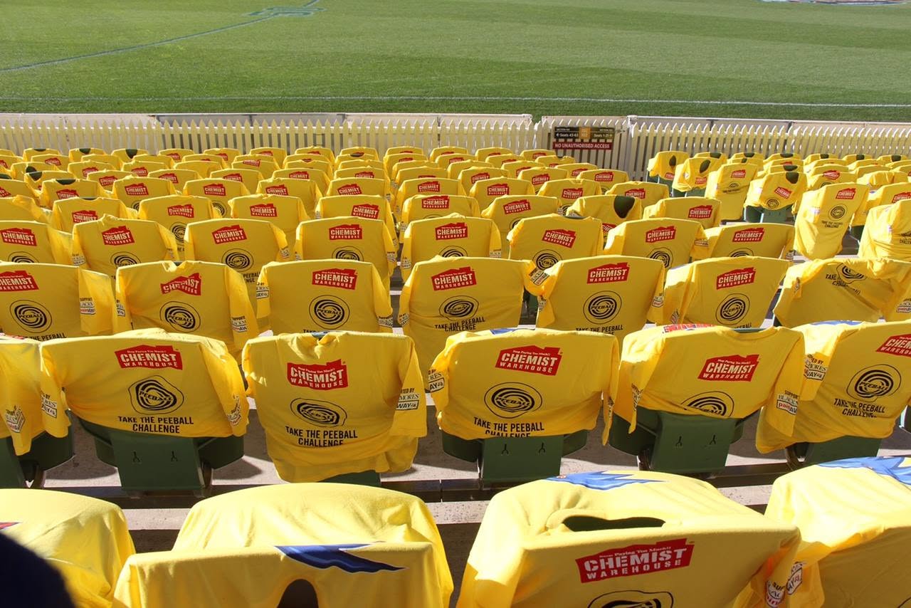 Rows of yellow Peeball T-shirts covering the stadium seats
